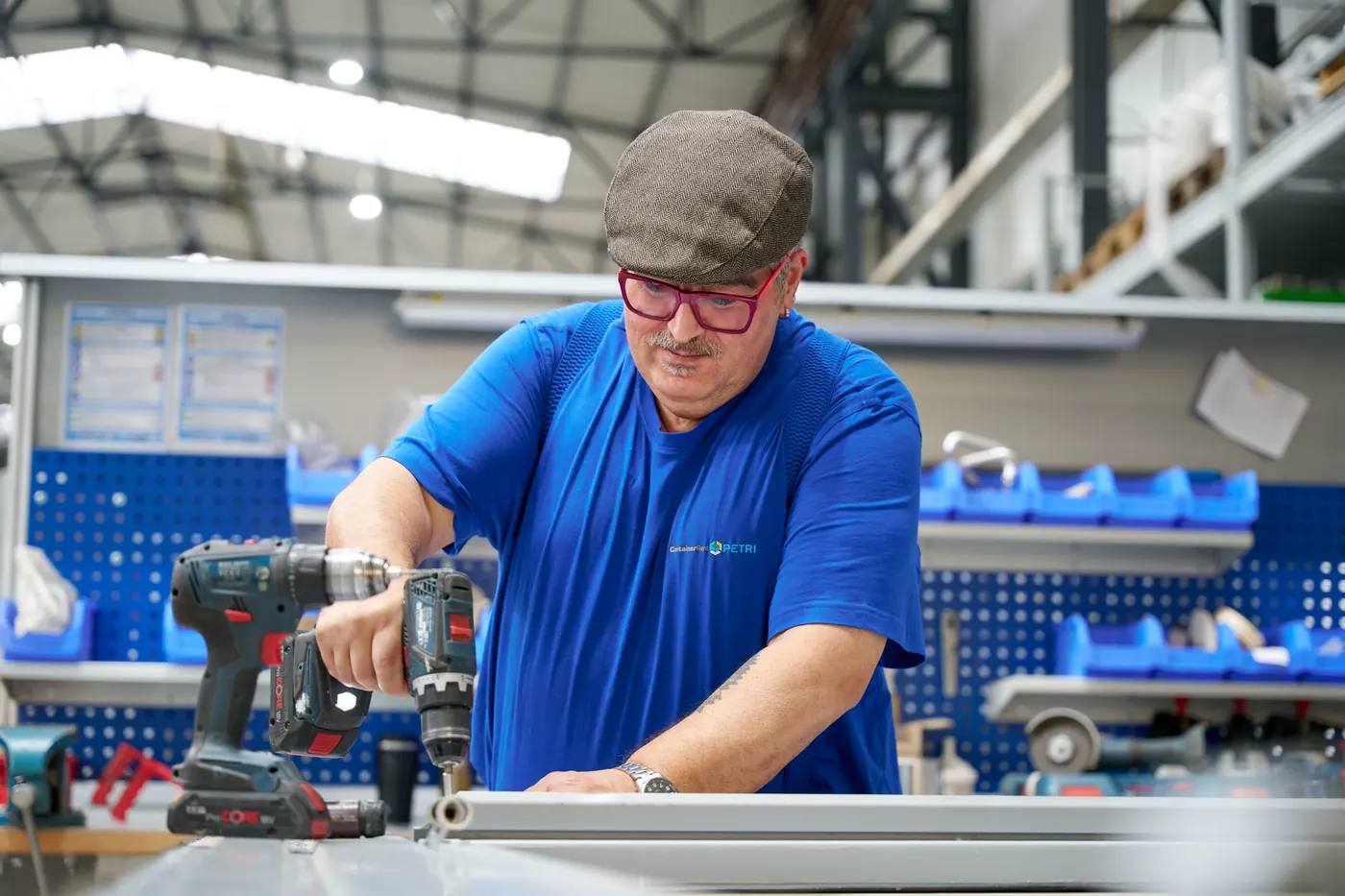 Mitarbeiter bohrt an der Werkbank ein Aluminiumprofil