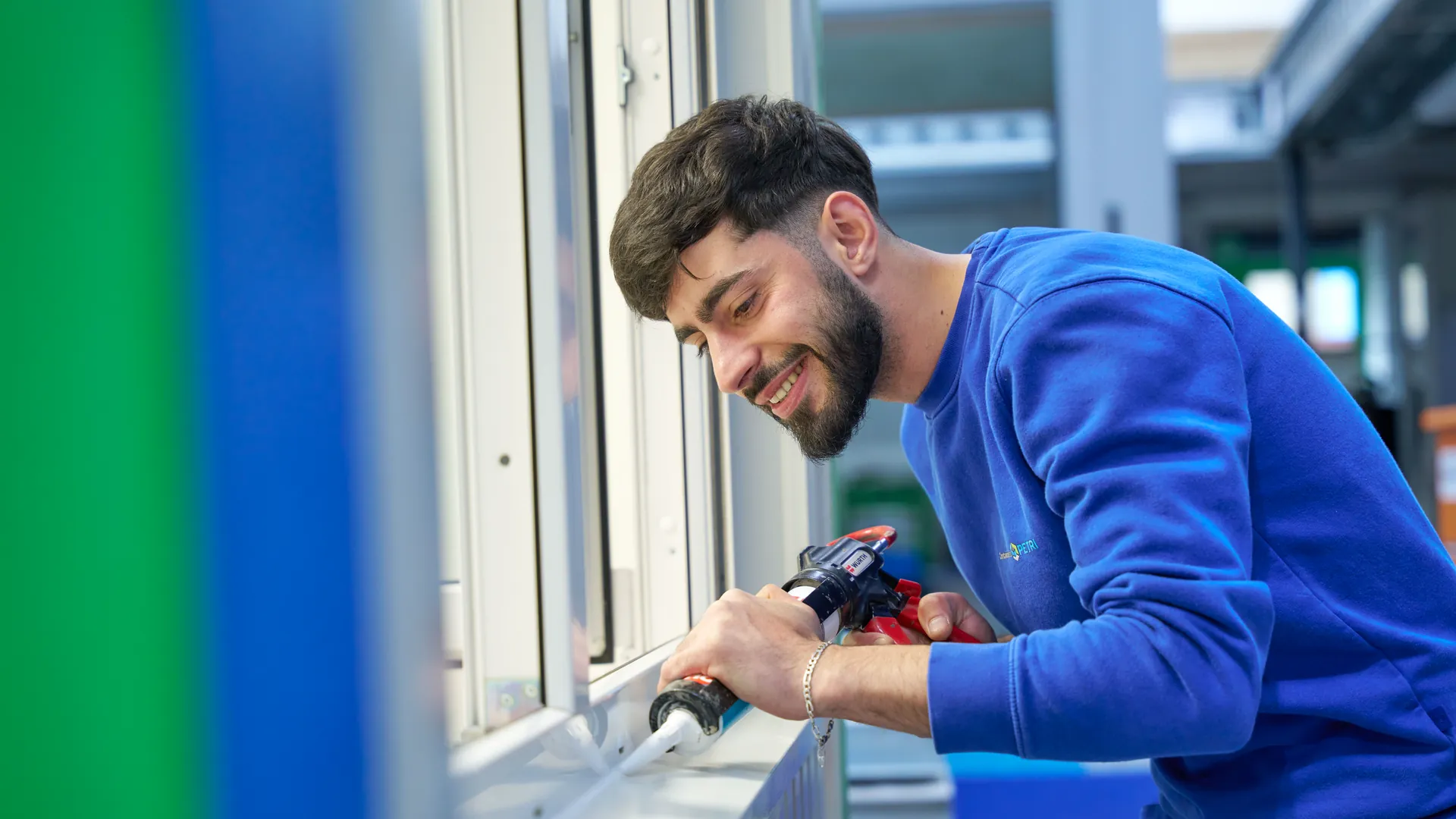 Mitarbeiter von Container Rent Petri dichtet im Werk Herdorf ein Fenster eines Raummoduls ab